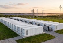 Impianto industriale di sistemi di accumulo energetico a batteria immerso nel verde